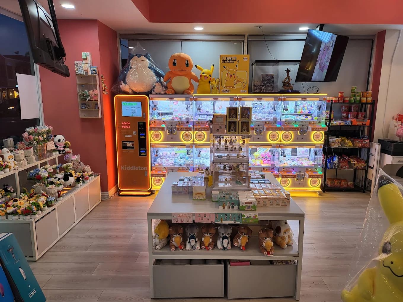 imizzu shop floor with a gift table of plush and blind boxes in front of a wall of claw machines